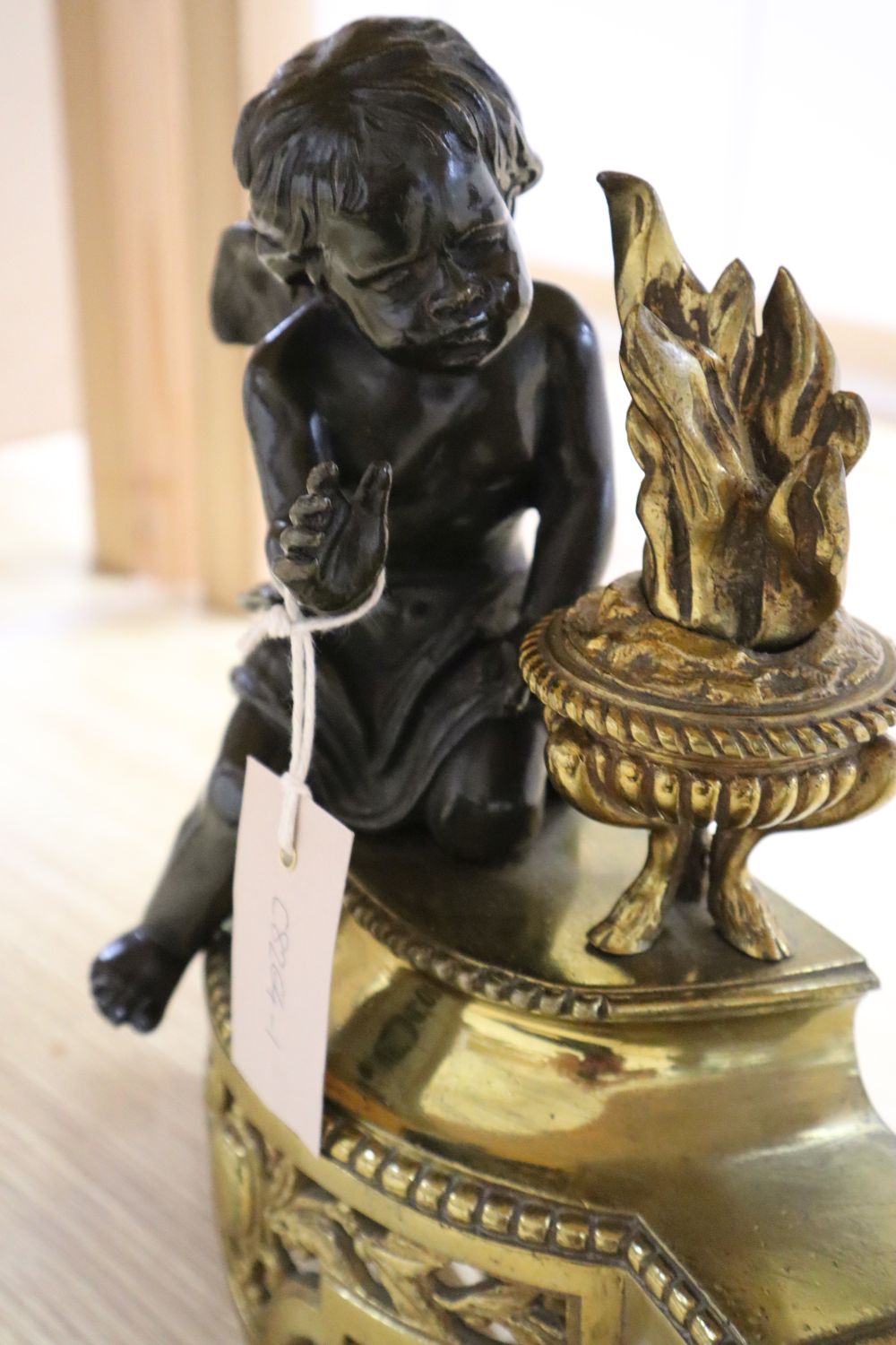 A 19th century French brass fender, classical style with two bronze cherub attendants, width adjustable 129cm max.